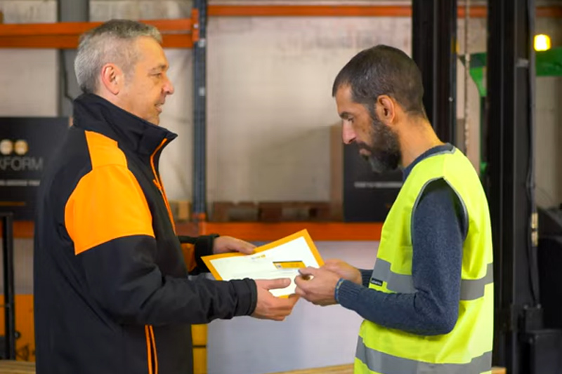Instructor del curso de carretillero entregando certificado de capacitación y carnet de carretillero trekform.